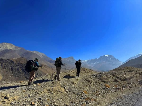 Local Guide Leading Trekkers Up Steep Ascent Pointing To Viewpoint